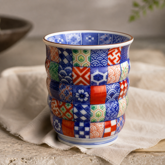 Luxury ecommerce image of a multicolor Kyoto ware inspired yunomi cup with hand-painted komon motifs